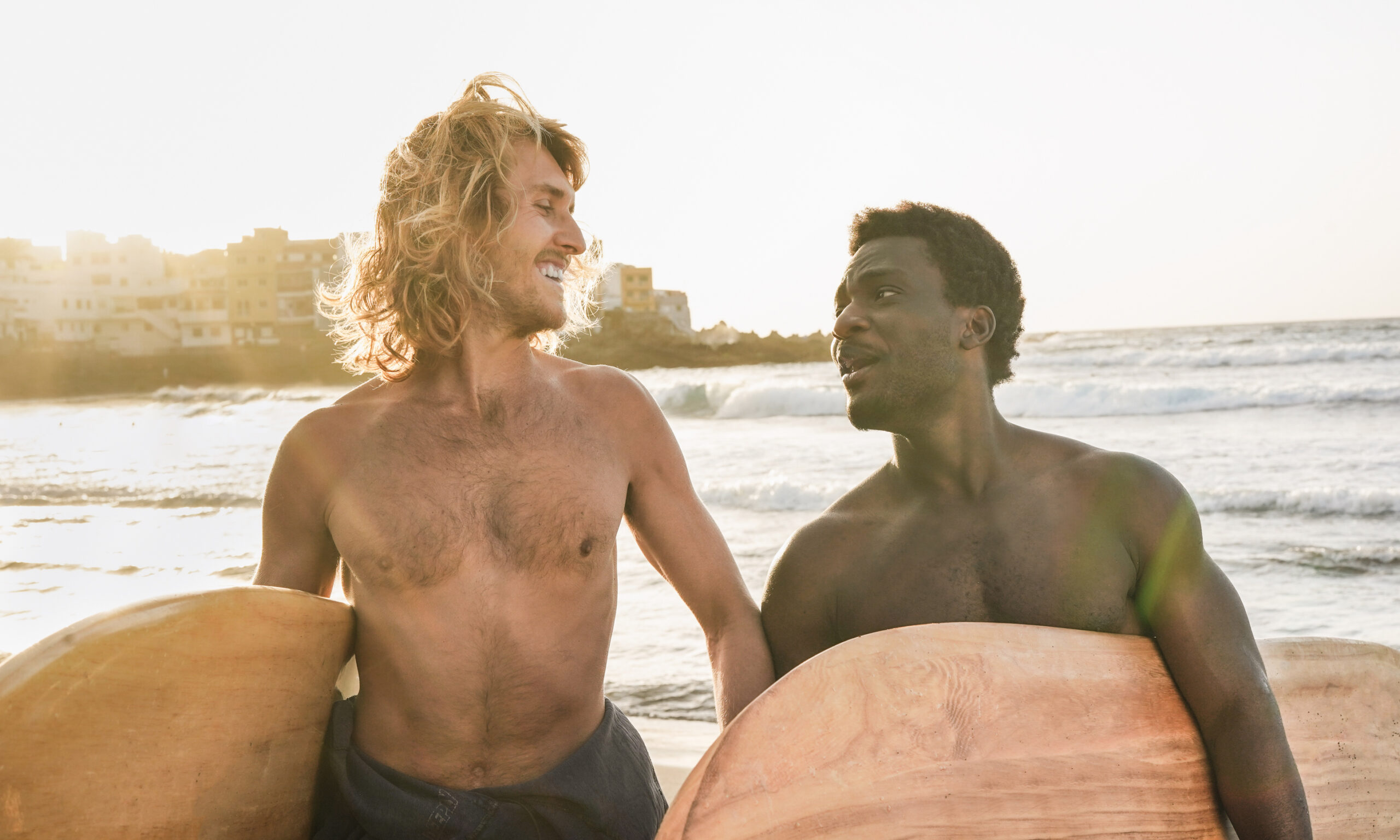 Happy multiracial surfer men having fun on the beach - Young peo