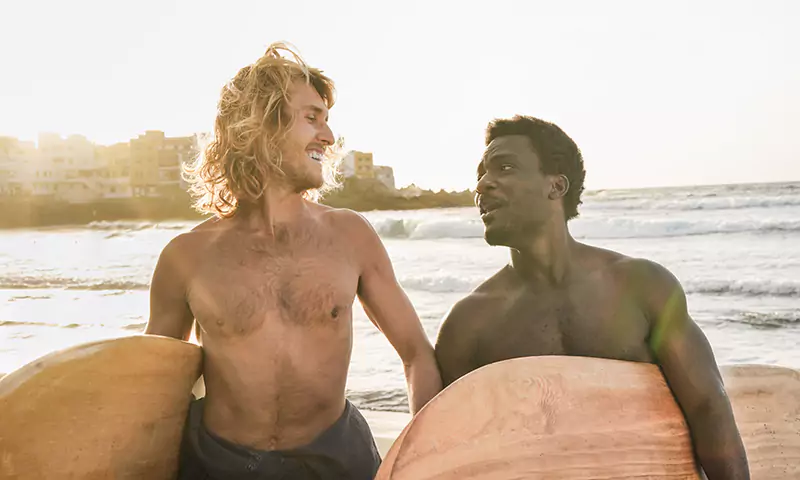 happy-multiracial-surfer-men-having-fun-on-the-bea-2022-02-01-22-36-06-utc-scaled