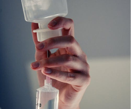 A person preparing an IV injection