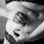 A woman measuring her belly